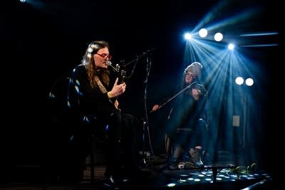Two musicians performing onstage in a music venue