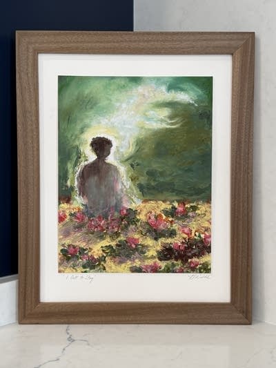 A painting sits in the corner, depicting a person sitting with flowers around them and a dark sky with a cloud.