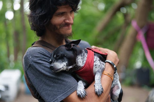 A dog rests its head against its owner's chest.