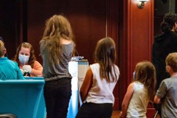 Kids wait in line for a vaccine.