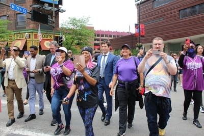 A group of people walk across the street