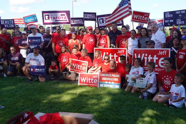 people gather for photo holding signs