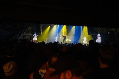 A hip-hop group performing onstage in a music venue