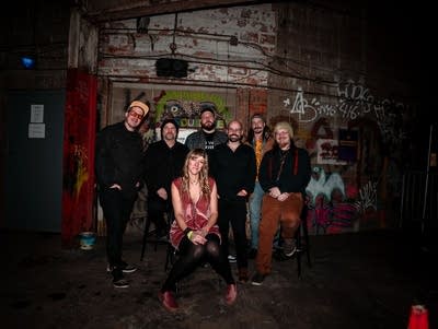 Seven people pose for a photo in a garage.