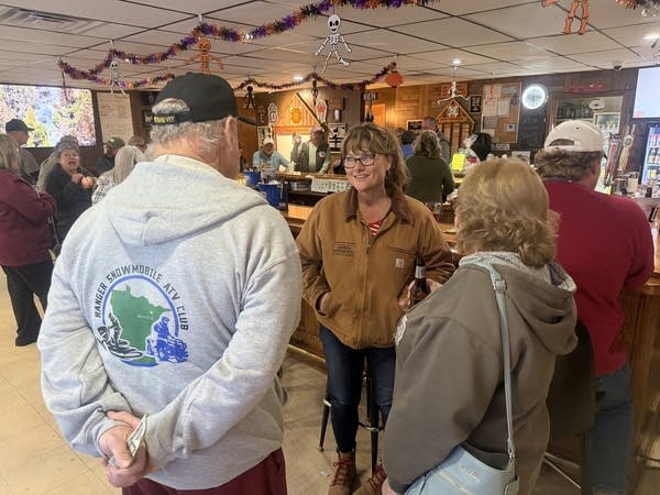 A woman talks to people at a local VFW bar.