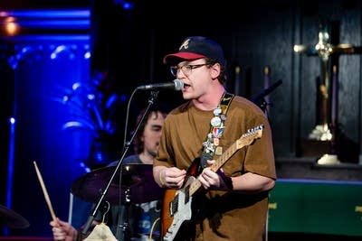 a guitarist singing and playing on stage