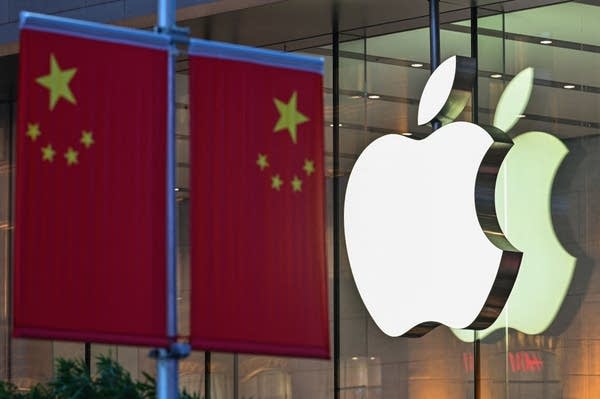 The Chinese national flag is displayed in front of an Apple store in Shanghai on October 9, 2021.