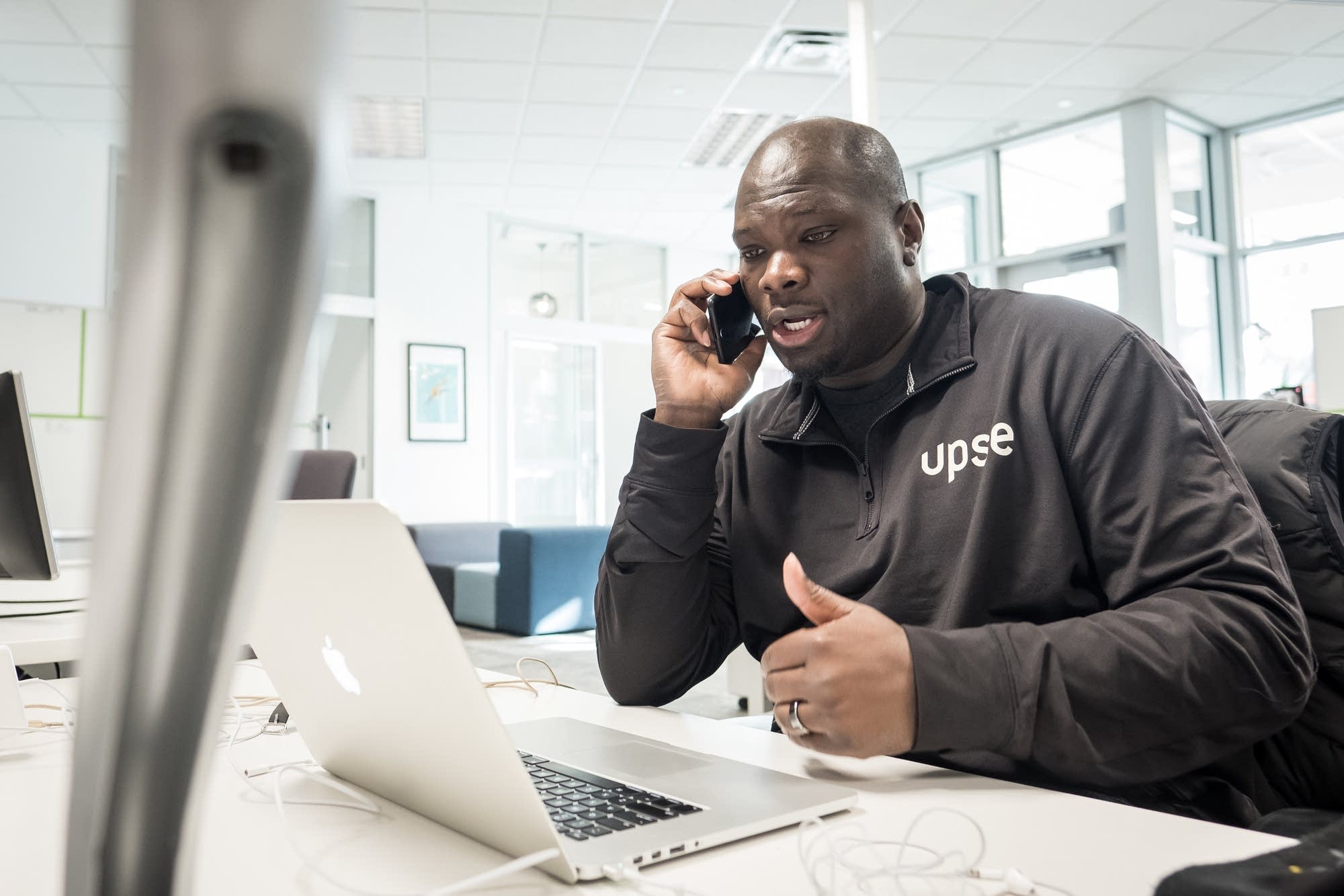 Clarence Bethea, CEO of Upsie, speaks on the phone at the Upsie office.