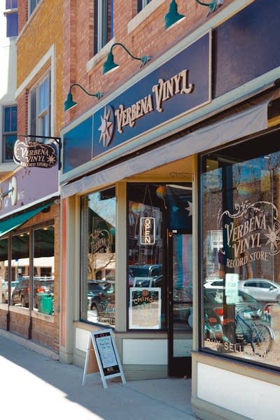 The exterior of a record store facade and display window in a building on a commercial street