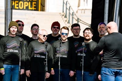 A choir singing on an outdoor stage at a large rally