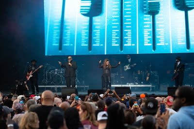 Jimmy Jam and Terry Lewis perform on an outdoor stage.