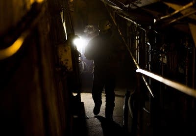 A worker walks through a tunnel in a lower level.