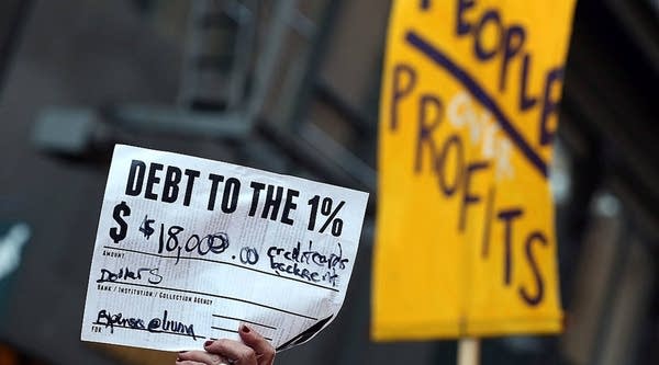 An Occupy Wall Street protestor holds up a mock debt note during a demonstration in San Francisco, California.