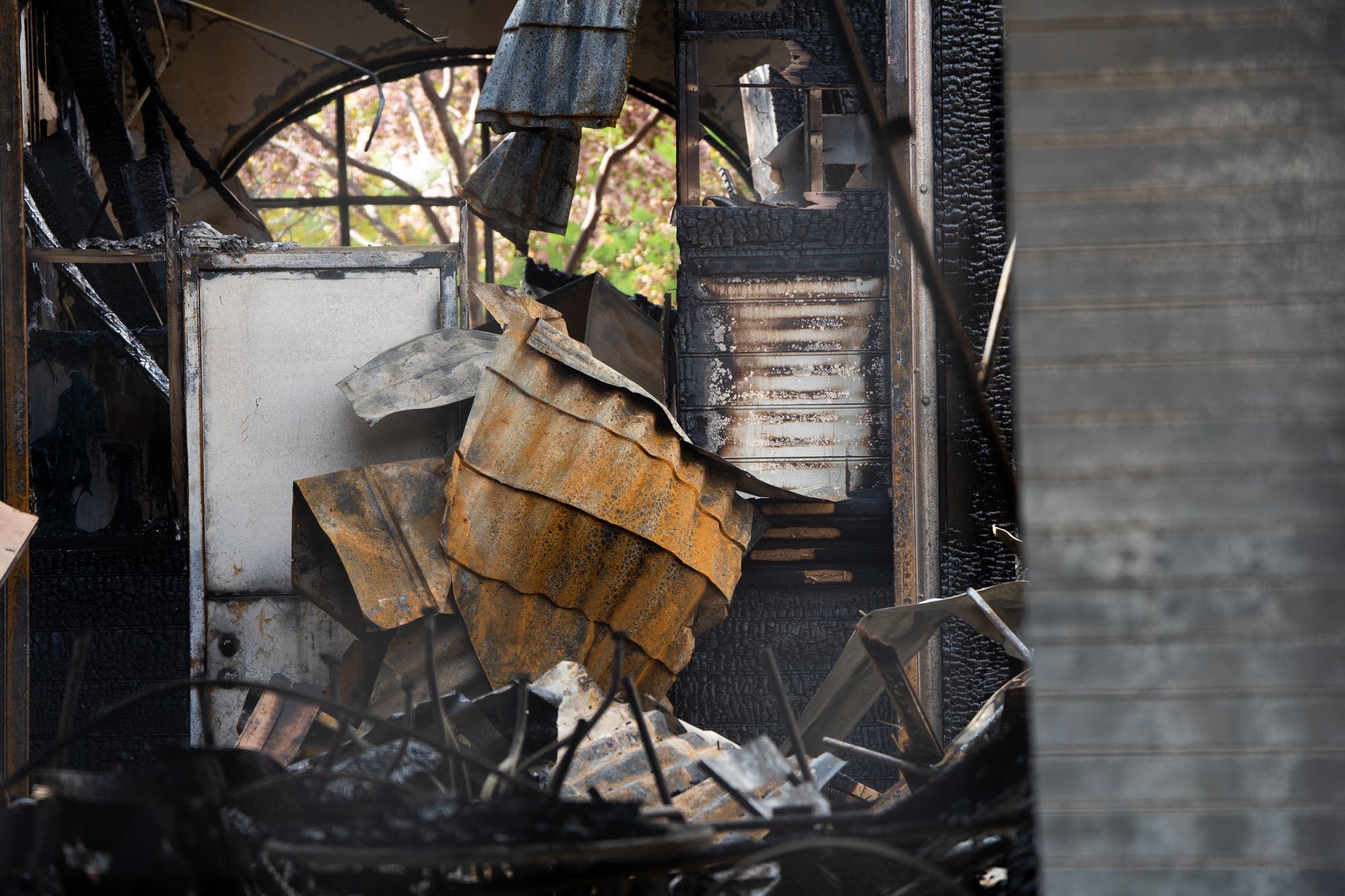 Charred wood and metal is seen inside of the pavillion on Bde Maka Ska.