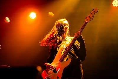 A musician plays bass onstage in a music venue