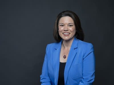 A%20woman%20with%20dark%20hair%20wearing%20a%20blue%20suit%20jacket%20