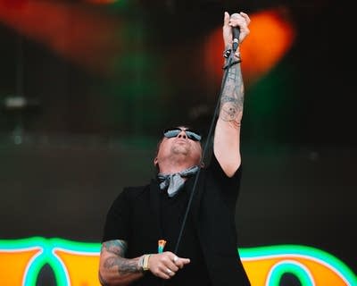 A musician sings on a large outdoor stage