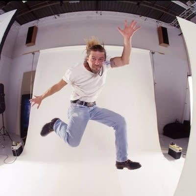 A man jumps in front of a white backdrop.