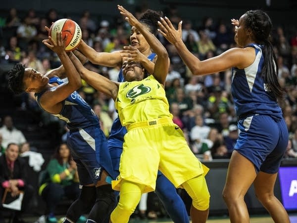 Three Lynx players surround a Storm player with the ball.