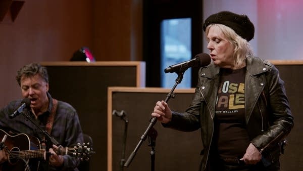 Two musicians perform together in a small auditorium