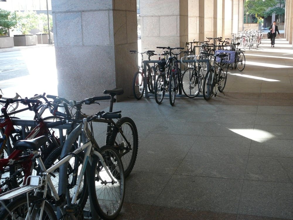 Bike commuters use a crowded bike rack.