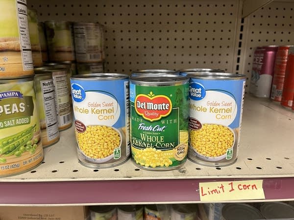Cans of corn sit on a shelf