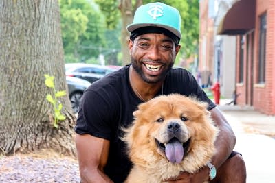man with dog poses for photo outside 