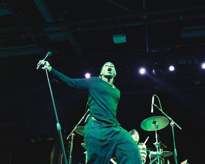 A musician sings and dances during on onstage performance