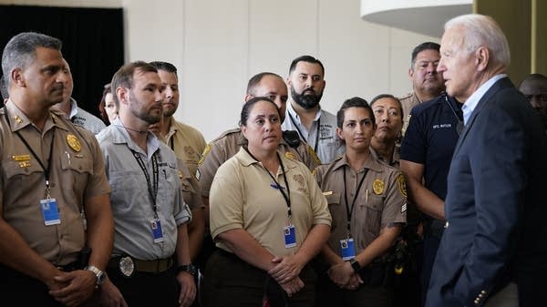 A man stands in front of a crowd of first responders.