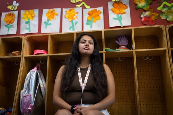 A woman sits for a portrait next to a row of cubbies