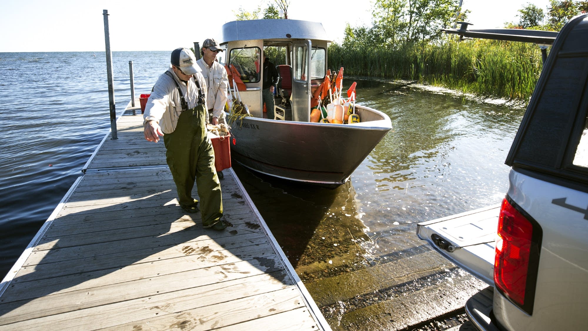 DNR employees Kris Nissen, front, and Greg Berg carry in their catch.
