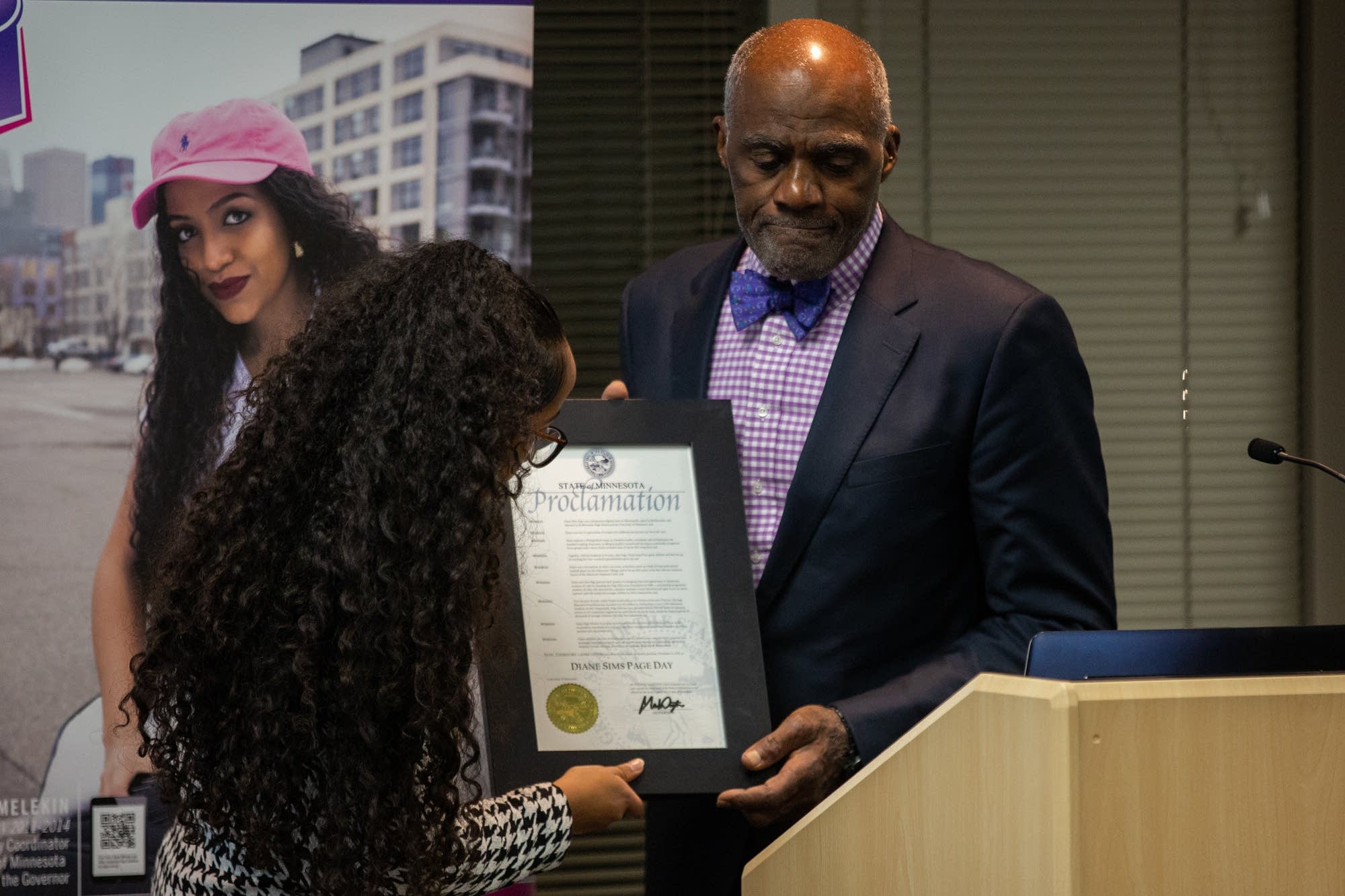 Justice Alan Page holds a proclamation from Gov. Mark Dayton