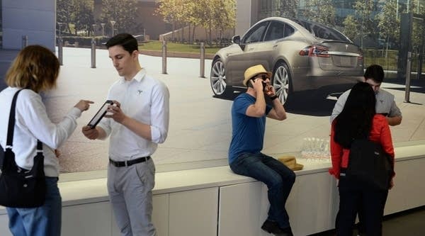 A salesman helps a customer pre-order the as-yet-unseen Tesla Model 3 in the Tesla store in Santa Monica, California, on March 31. 