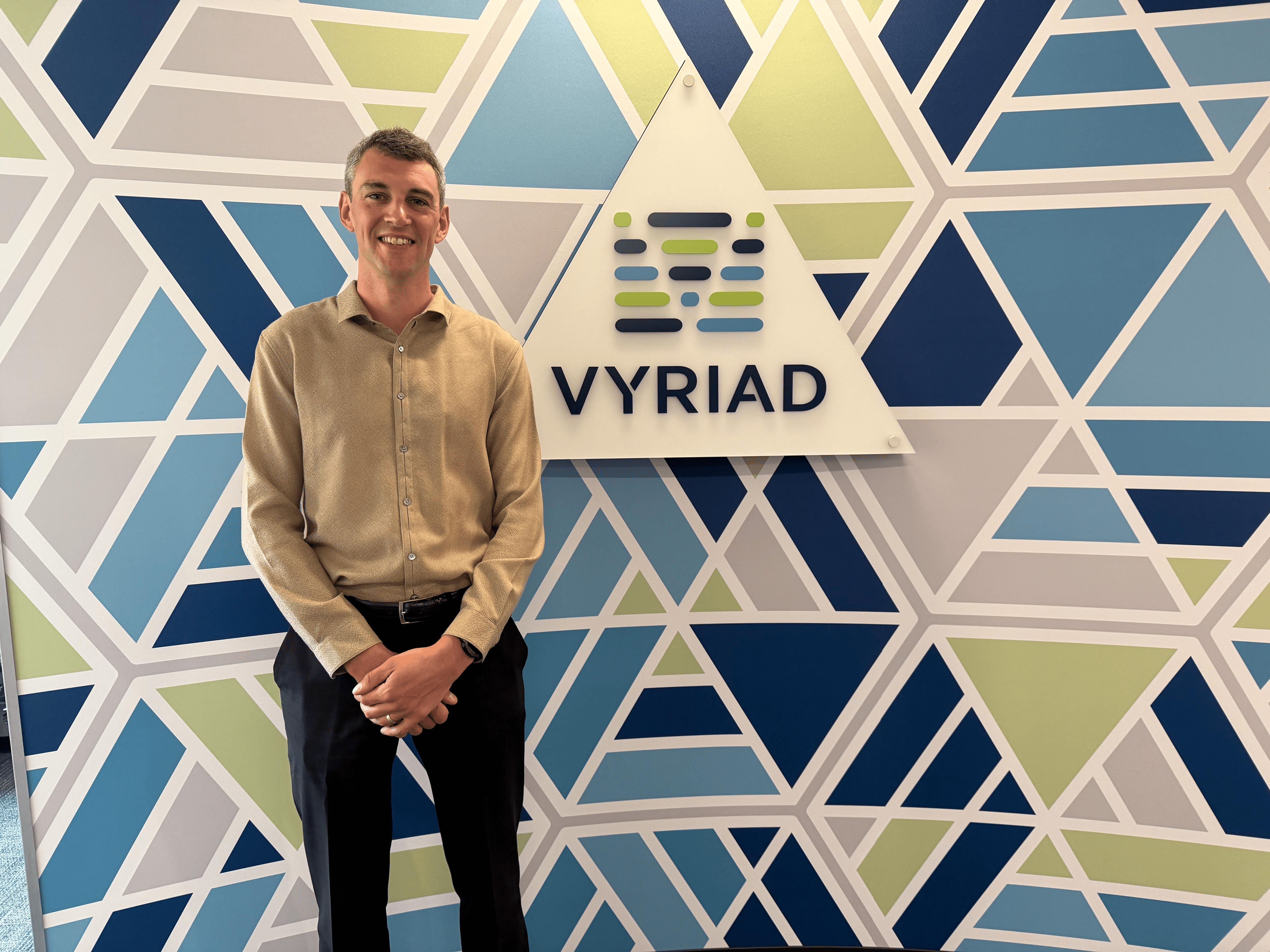 A man posing by Vyriad sign