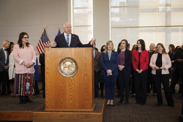 Person speaks at podium next to crowd03