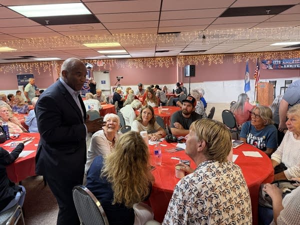 A man speaks to people seated at a table