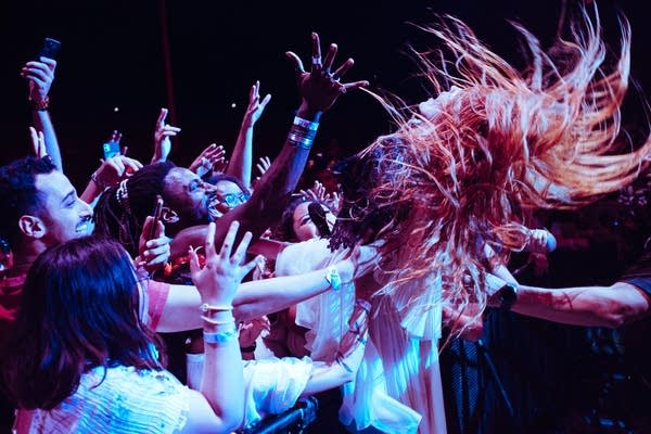A woman sings into a microphone on a stage