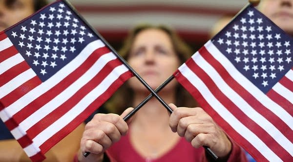 A supporter of Republican presidential candidate, former Massachusetts Gov. Mitt Romney holds American flags as she looks on during a campaign rally. Petitions for state secessions are popping up, but are they economically feasible?