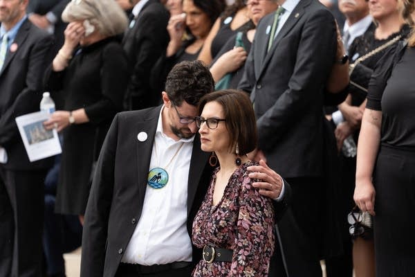 two people embrace at funeral