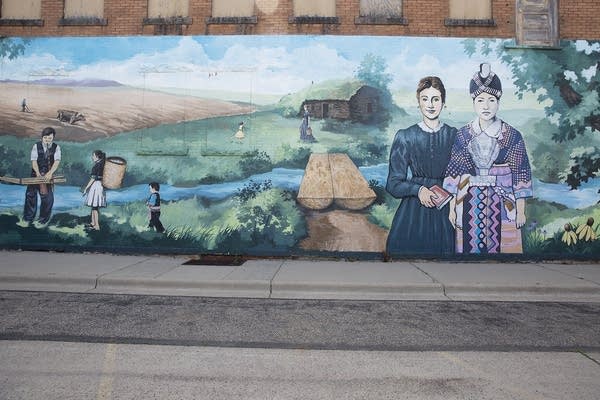 A mural covers an entire brick wall on the outside of a building. 