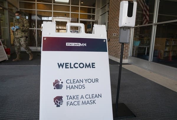 A sign reads "Welcome. Clean your hands. Take a clean face mask."