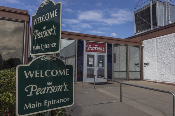 A green sign in front of double doors says "Welcome, Pearson's Main Entrance."