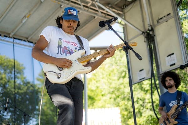 Two musicians performing on an outdoor stage
