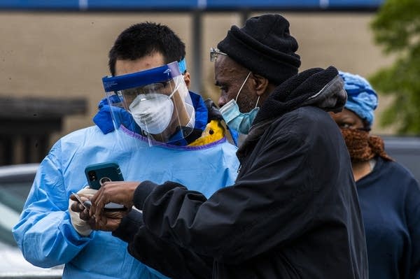 A volunteer checks a patient to be tested for Covid-19