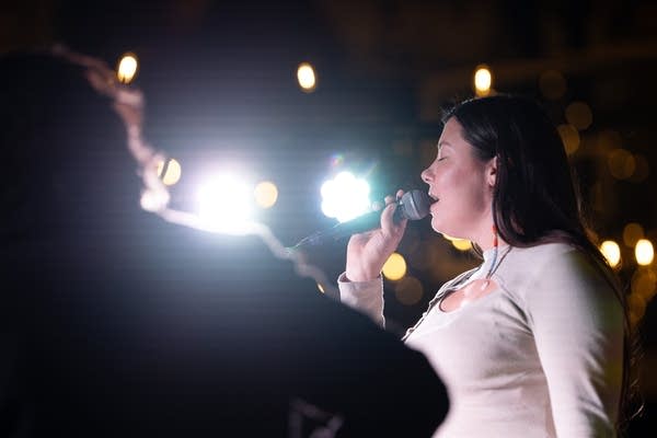 A woman sings on a stage.