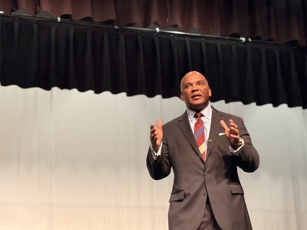 A man speaks from a stage