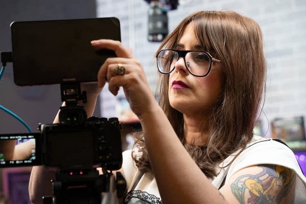 A woman looks at a screen.
