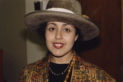 A woman in an elegant jacket and wide-brimmed hat