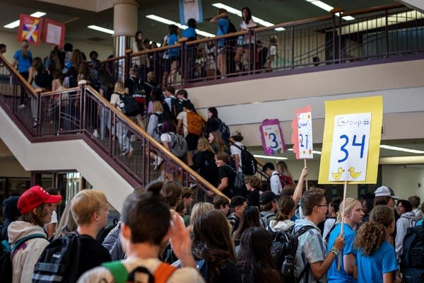 Students move through school hallways and up a staircase