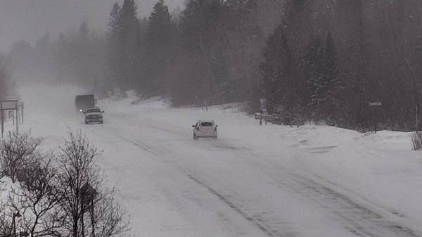 Traffic moves along a snowy highway